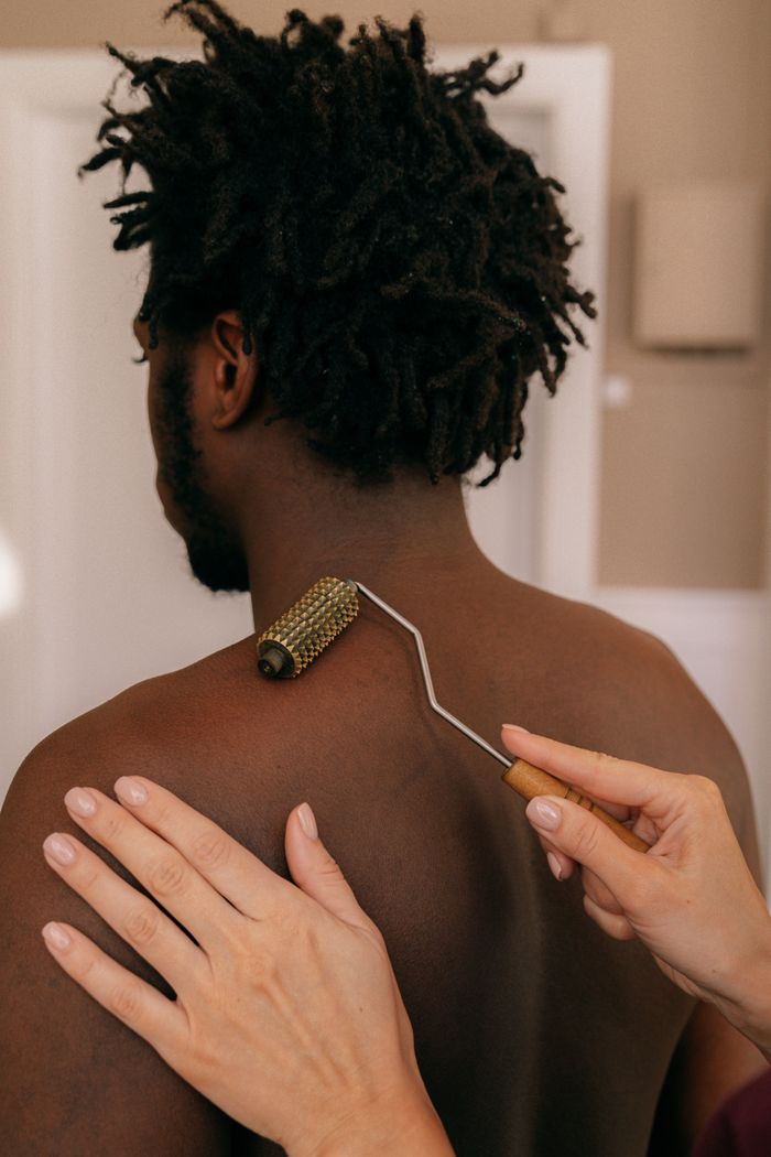 A relaxing back massage using a jade roller, focusing on wellness and self-care.